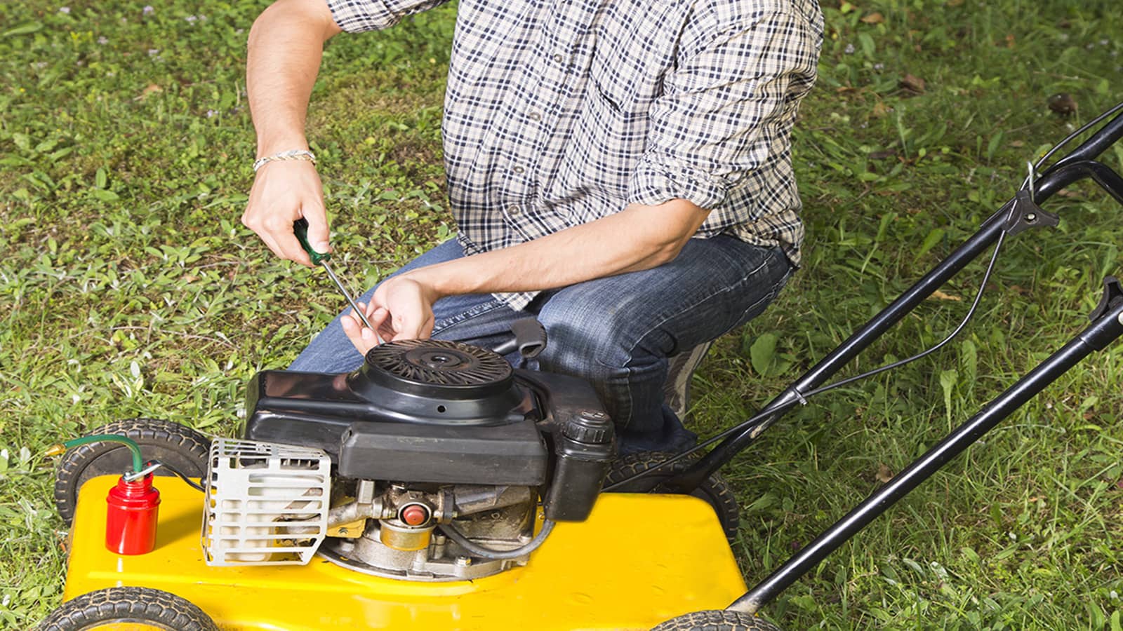 Man Doing Maintenance On Lawn Mower In Winter